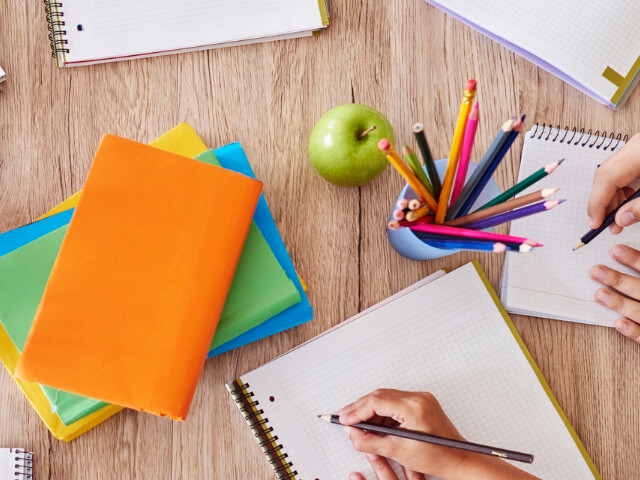Bunte Stifte mit Heften auf einem Schreibtisch