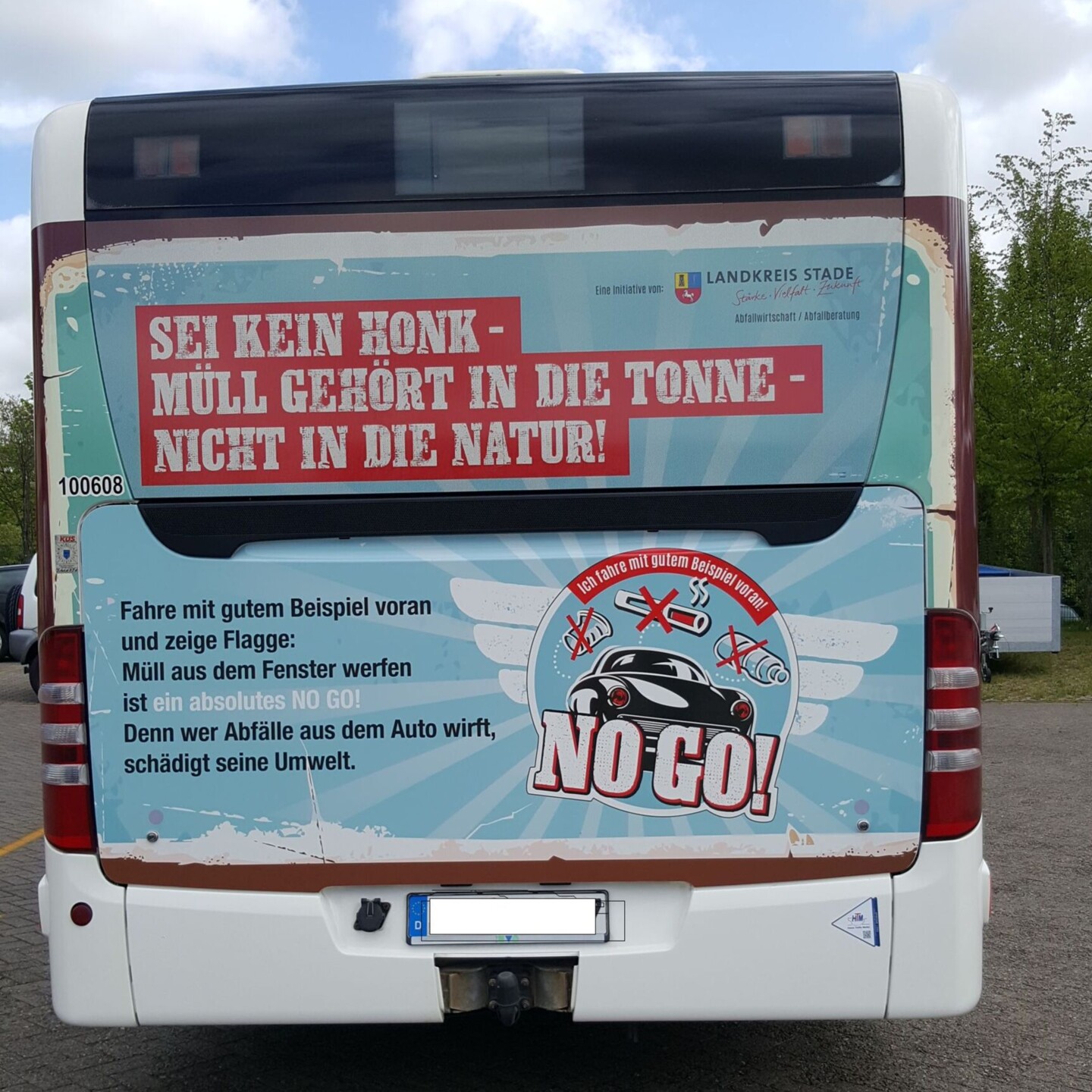 Die Rückseite eines Busses, die mit dem NO GO Großplakat beklebt ist.